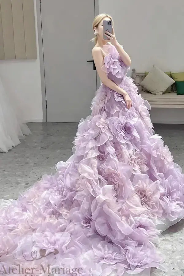 Vue de côté soulignant la traîne majestueuse entièrement composée de fleurs 3D lilas, un design d'exception signé Atelier Mariage.