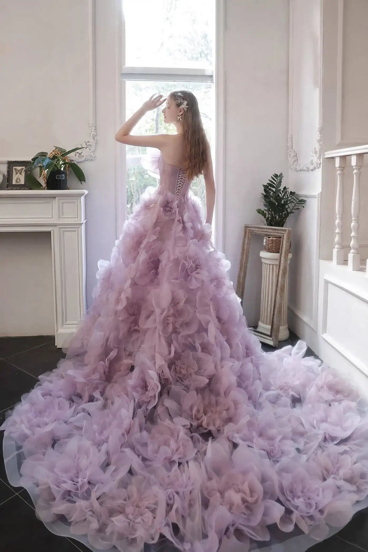 Vue de dos montrant la traîne majestueuse de 130 cm de la robe de mariée lilas ornée de fleurs 3D.