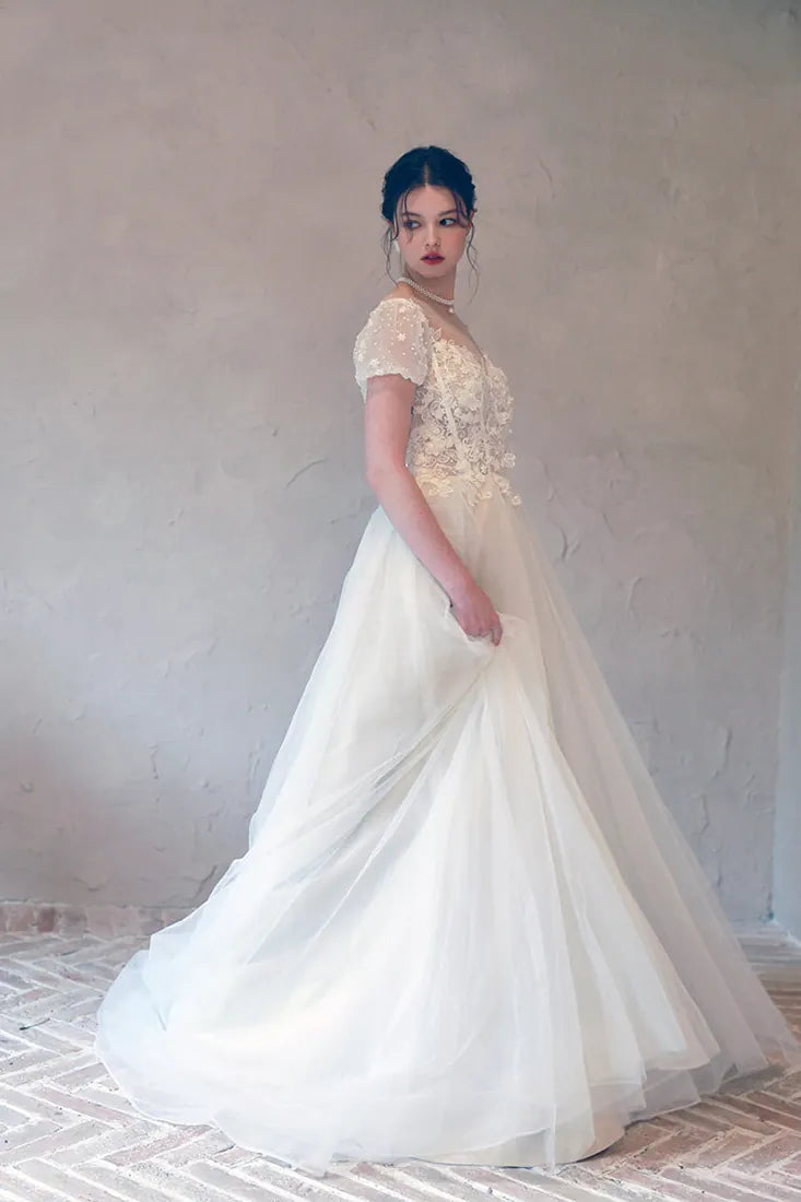 Jeux de lumière et transparence sur les fleurs brodées du corsage.