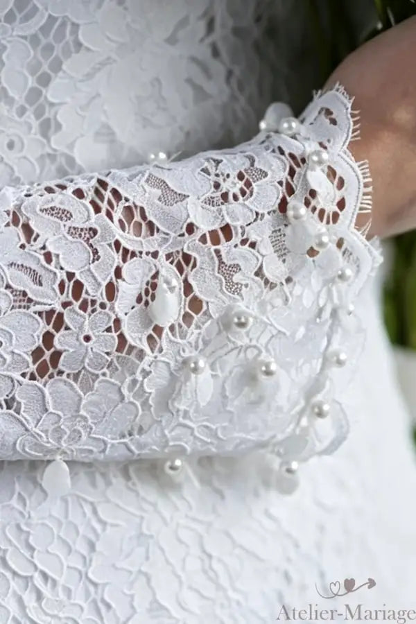 Focus sur la ligne de manchette et la structure de la robe orientale, illustrant l'expertise en coupe et montage de l'atelier.