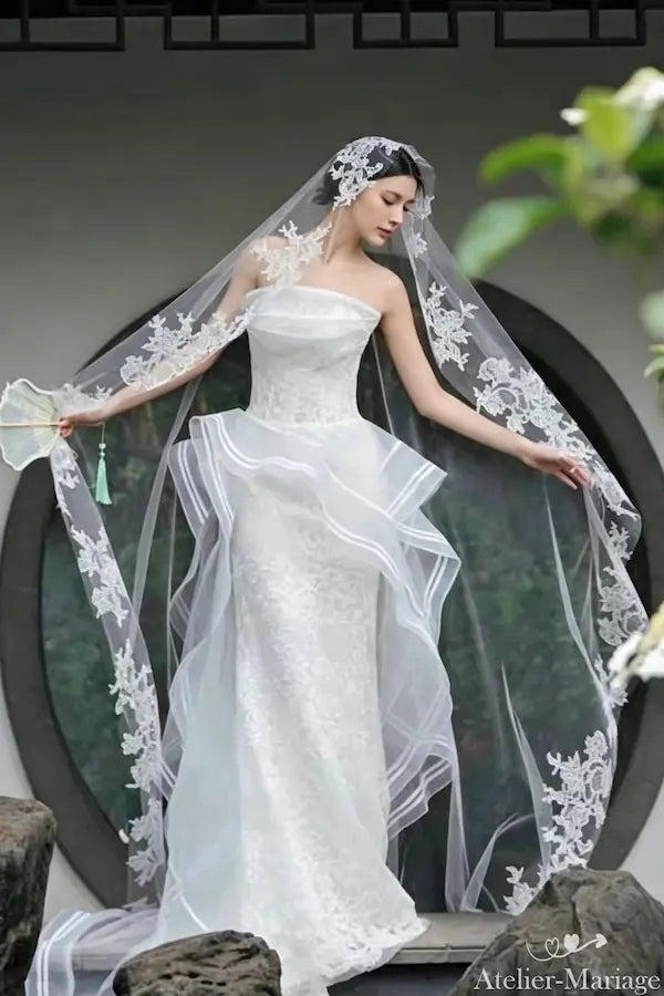 Vue rapprochée du buste et de la tête portant le voile de mariage 3m en dentelle, montrant la retombée élégante et les motifs floraux