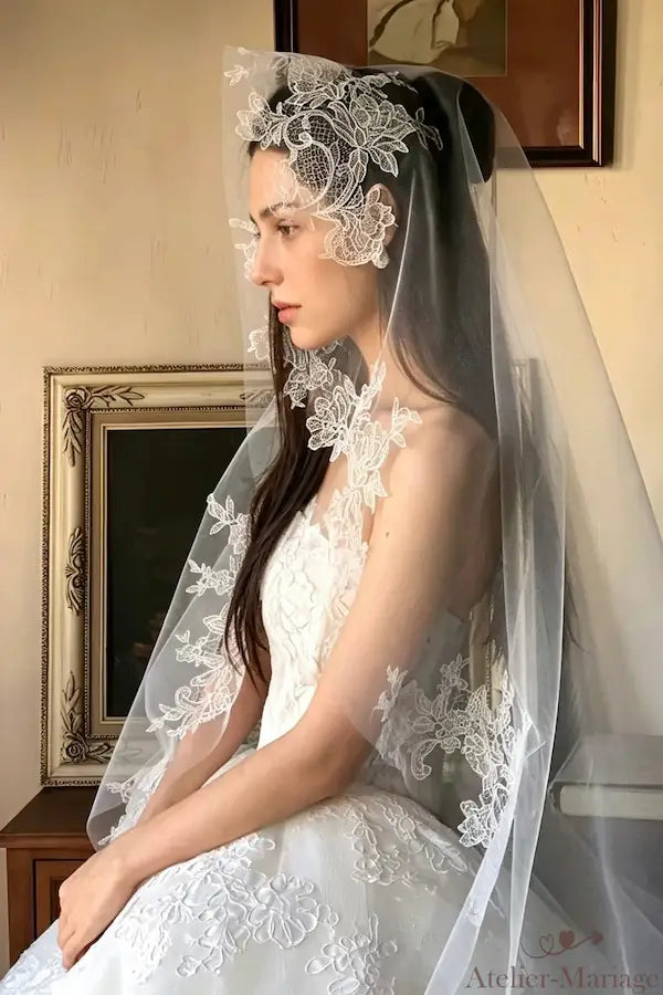Portrait romantique de profil en intérieur, le voile en dentelle guipure de 3 mètres encadre le visage de la mariée