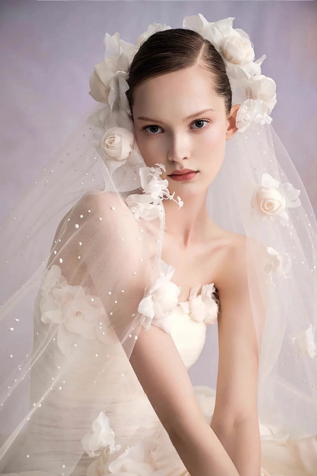 Mariée portant un voile assorti avec des applications de fleurs 3D et perles.