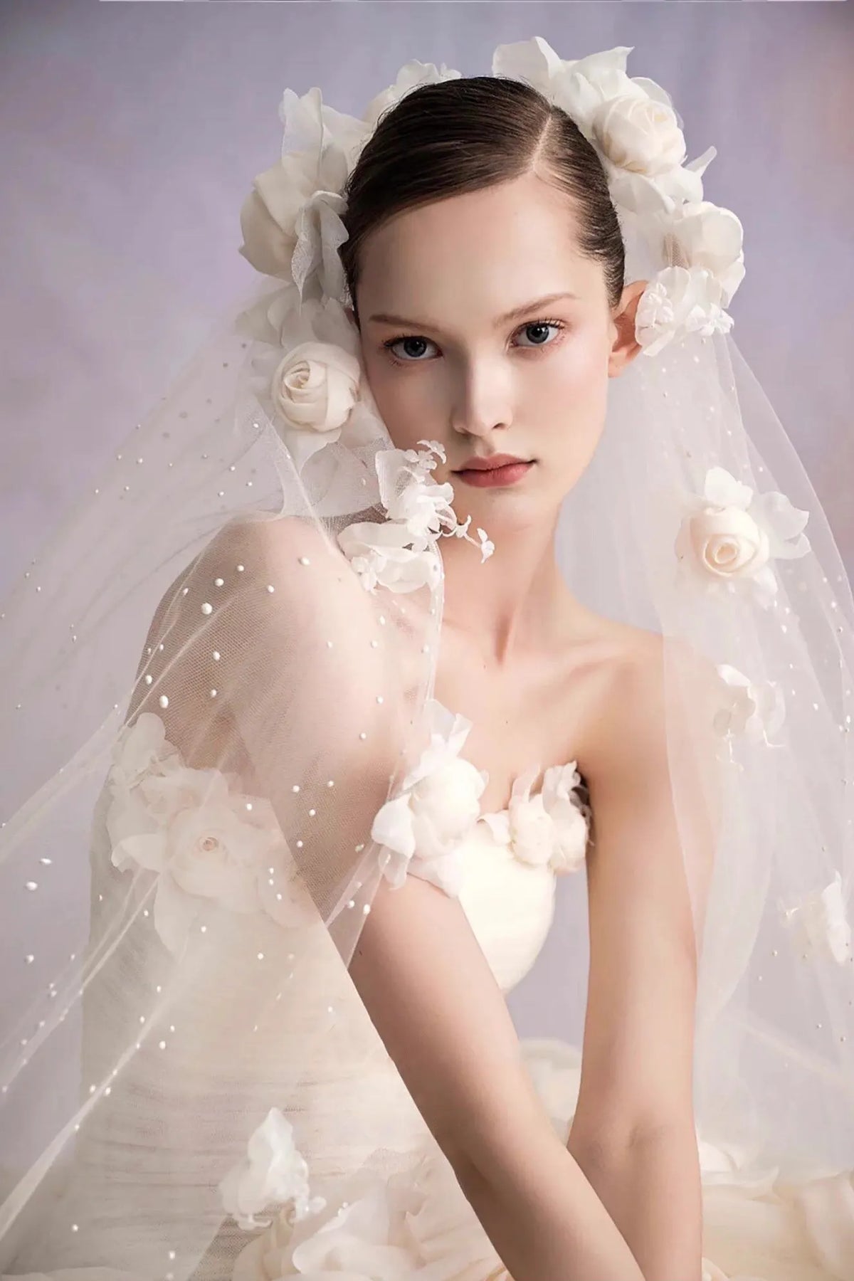 Mariée portant un voile assorti avec des applications de fleurs 3D et perles.