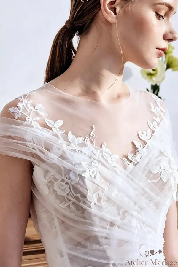 Détail technique du placement des perles et de la dentelle, artisanat d'exception.
